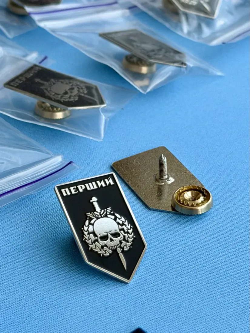 піни «ПЕРШИЙ» з черепом, видно метелик і голку